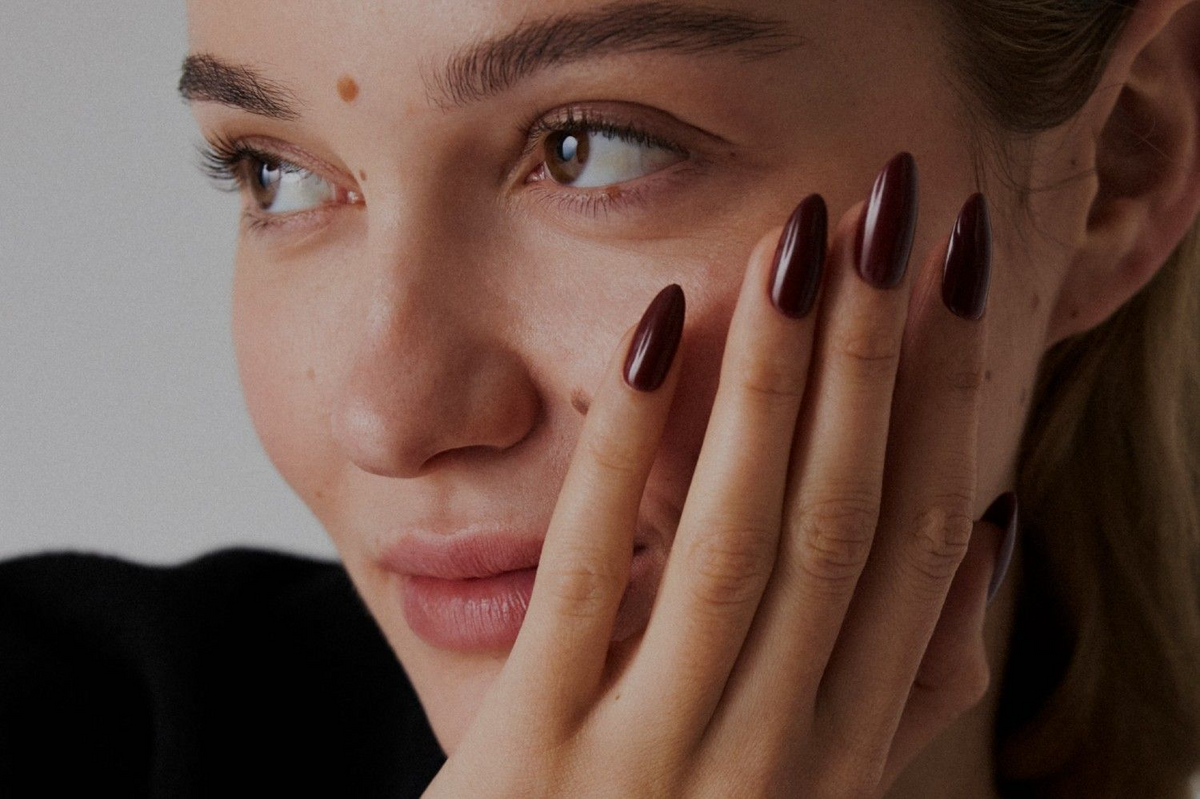 Cliente sorridente con una manicure scura